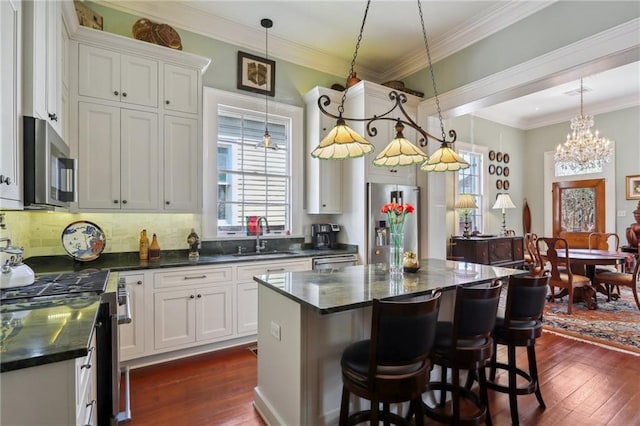 kitchen featuring stainless steel appliances, a kitchen island, dark hardwood / wood-style flooring, and sink