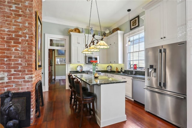 kitchen featuring a kitchen island, white cabinets, dark hardwood / wood-style flooring, pendant lighting, and appliances with stainless steel finishes