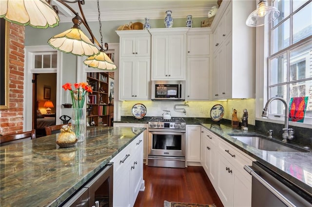 kitchen featuring pendant lighting, appliances with stainless steel finishes, sink, and white cabinetry