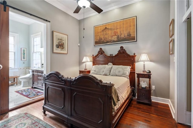 bedroom featuring ceiling fan, ornamental molding, dark hardwood / wood-style floors, ensuite bath, and a barn door