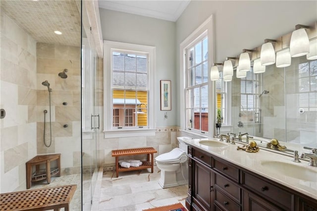 bathroom featuring vanity, tile walls, crown molding, a shower with shower door, and toilet