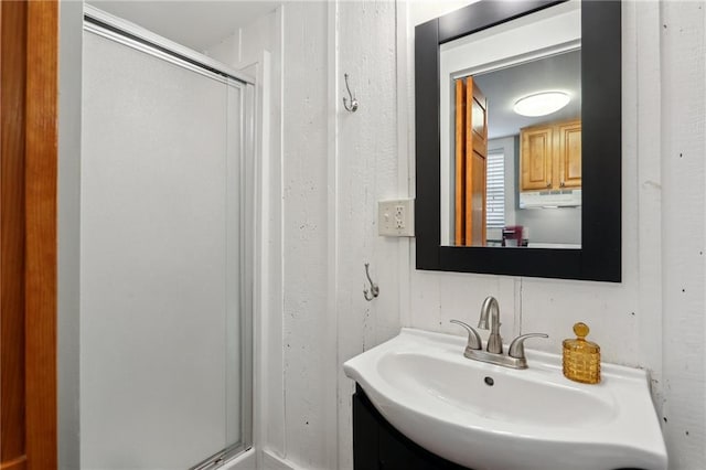 bathroom with a shower with shower door and vanity