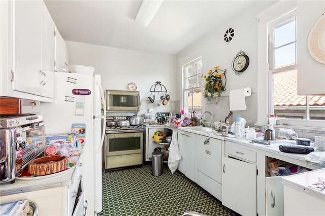 kitchen with appliances with stainless steel finishes, sink, and white cabinets