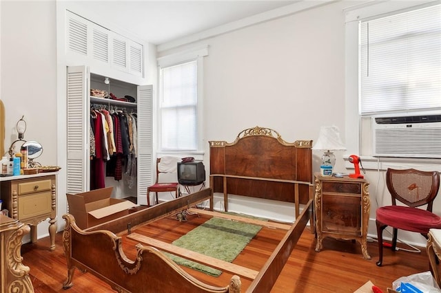 bedroom featuring a closet, hardwood / wood-style floors, and cooling unit