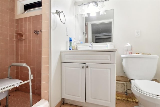 bathroom featuring tile patterned floors, a tile shower, vanity, and toilet