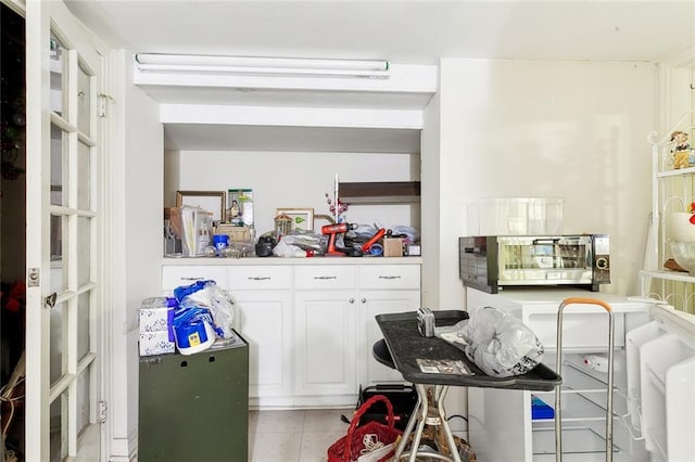 kitchen with light tile patterned floors and white cabinetry