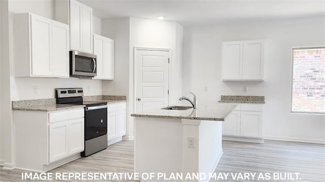 kitchen with light stone countertops, sink, an island with sink, white cabinets, and appliances with stainless steel finishes