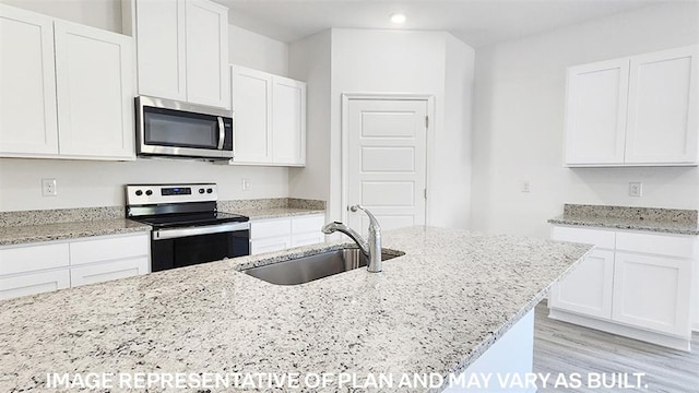 kitchen with white cabinets, light hardwood / wood-style floors, sink, and appliances with stainless steel finishes