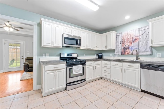 kitchen featuring appliances with stainless steel finishes, white cabinetry, sink, and light tile patterned floors