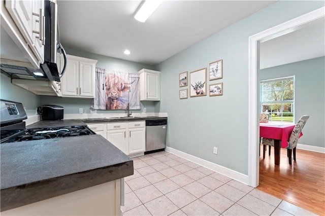 kitchen with light tile patterned flooring, stainless steel appliances, sink, and white cabinetry