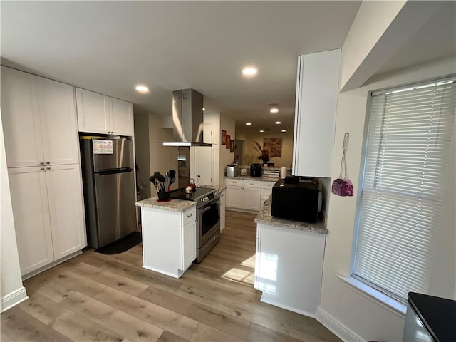 kitchen with stainless steel appliances, extractor fan, white cabinets, and light hardwood / wood-style flooring