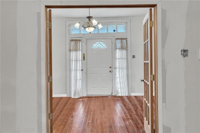 entryway with hardwood / wood-style flooring and a chandelier