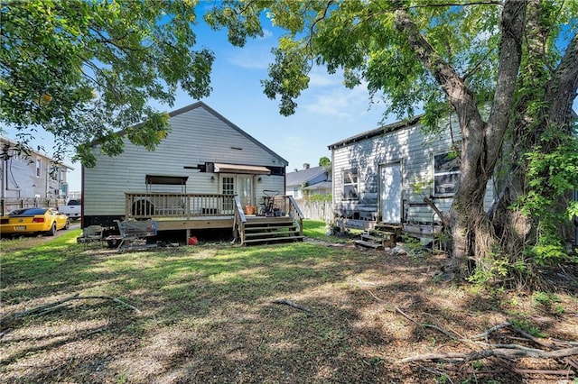 rear view of property featuring a yard and a wooden deck