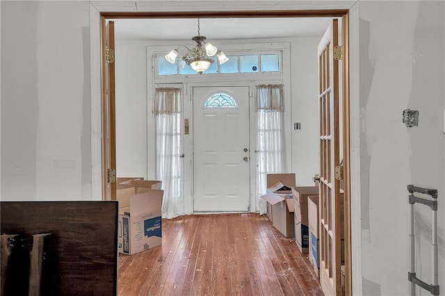 entrance foyer with wood-type flooring and an inviting chandelier