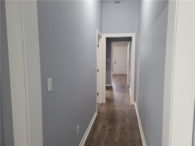 corridor with dark hardwood / wood-style flooring