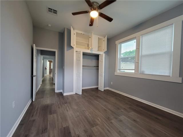 unfurnished bedroom featuring ceiling fan, a closet, and dark hardwood / wood-style flooring