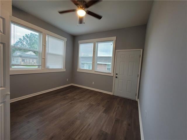 unfurnished room featuring ceiling fan and dark wood-type flooring