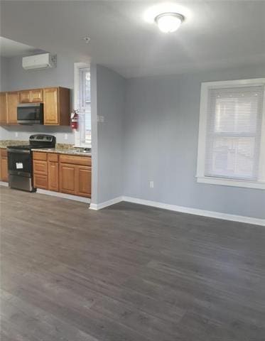 kitchen with stainless steel appliances, dark wood-type flooring, and an AC wall unit