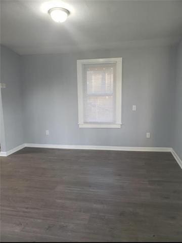 unfurnished room with dark wood-type flooring