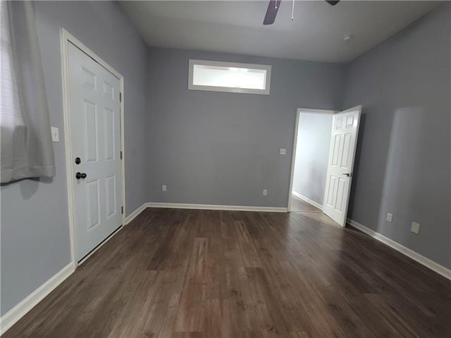 empty room with dark hardwood / wood-style floors and ceiling fan