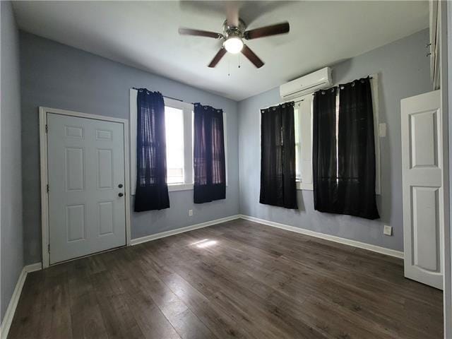 interior space featuring dark wood-type flooring, ceiling fan, and a wall mounted air conditioner