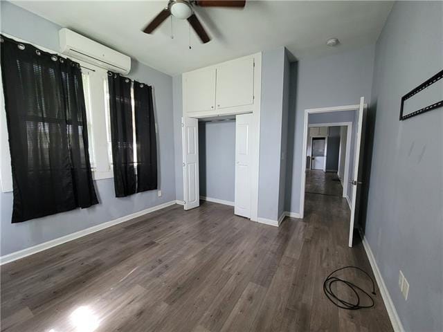 unfurnished bedroom featuring a wall mounted air conditioner, dark hardwood / wood-style flooring, and ceiling fan