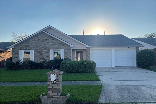 single story home featuring a garage and a yard