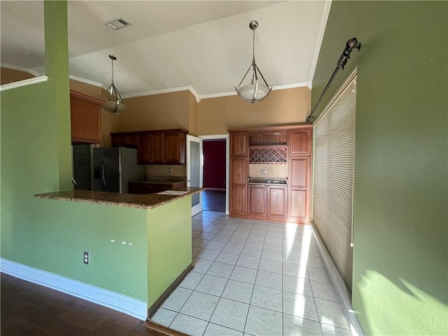 kitchen featuring kitchen peninsula, stainless steel refrigerator with ice dispenser, ornamental molding, and hanging light fixtures