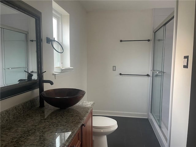 bathroom with toilet, tile patterned floors, vanity, and a shower with door