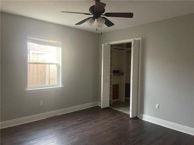 unfurnished bedroom featuring dark wood-type flooring, ceiling fan, and a closet