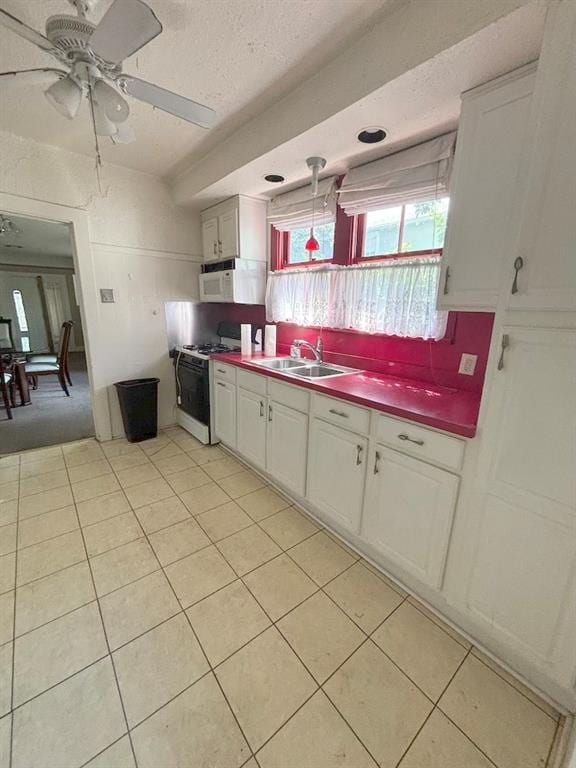 kitchen with light tile patterned floors, tasteful backsplash, sink, white cabinetry, and white appliances