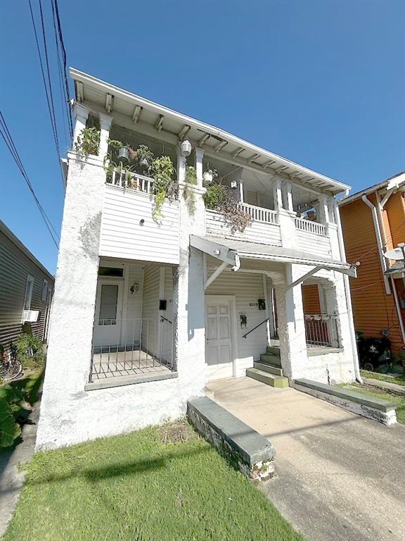 view of front of property featuring covered porch and a balcony