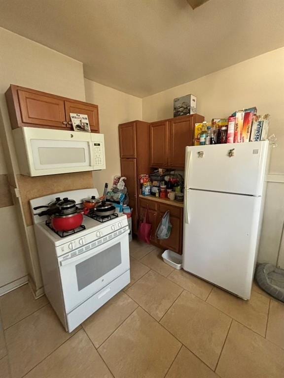 kitchen with white appliances and light tile patterned flooring