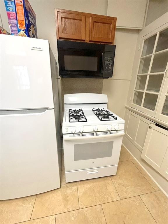 kitchen with light tile patterned floors and white appliances