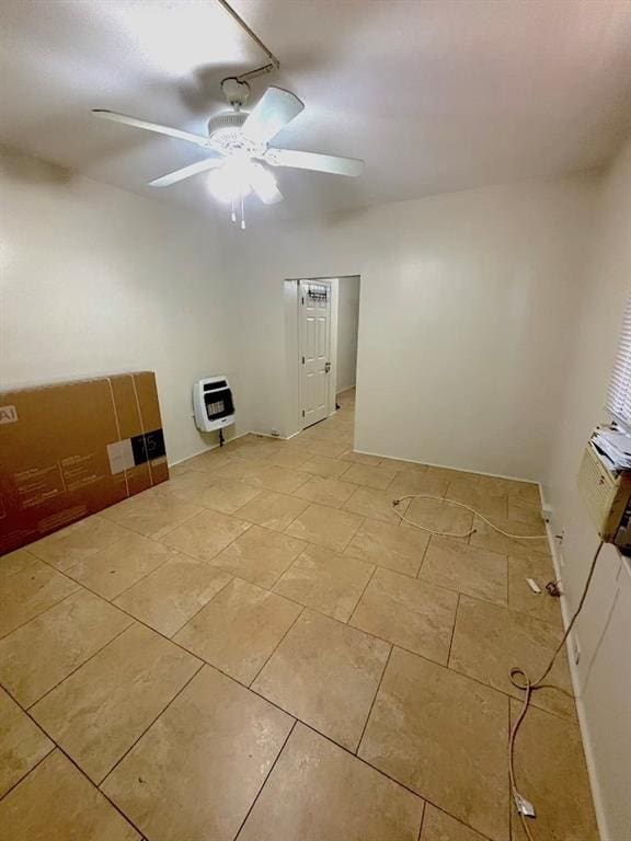 empty room featuring ceiling fan and heating unit