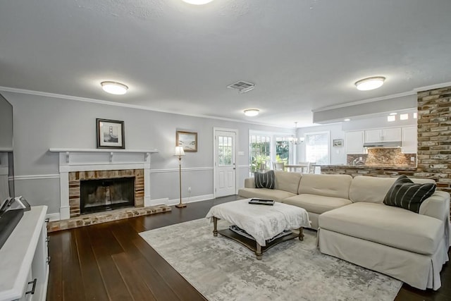 living room featuring a fireplace, ornamental molding, and dark hardwood / wood-style flooring