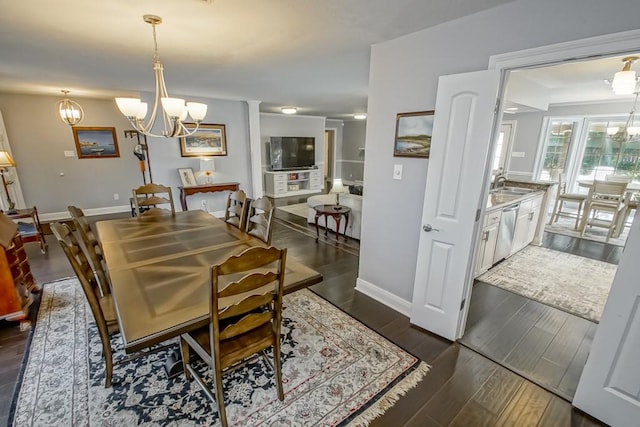 dining room with a notable chandelier, dark hardwood / wood-style flooring, and sink