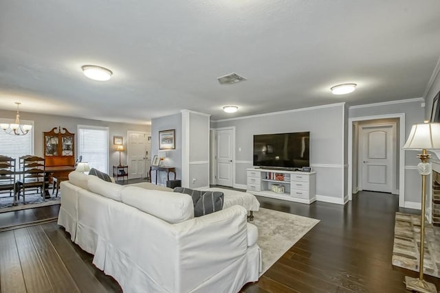 living room featuring ornamental molding, a notable chandelier, and dark hardwood / wood-style flooring