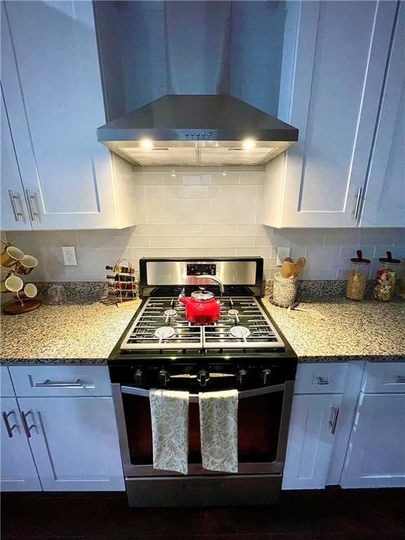 kitchen featuring white cabinetry, tasteful backsplash, wall chimney range hood, and stainless steel range with gas cooktop