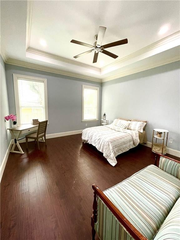 bedroom with dark wood-type flooring, ceiling fan, crown molding, and a tray ceiling