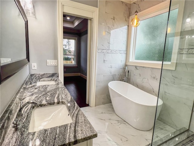 bathroom featuring tile walls, wood-type flooring, crown molding, vanity, and a washtub