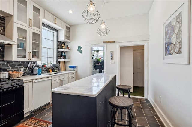 kitchen featuring white dishwasher, black gas stove, a healthy amount of sunlight, and a center island