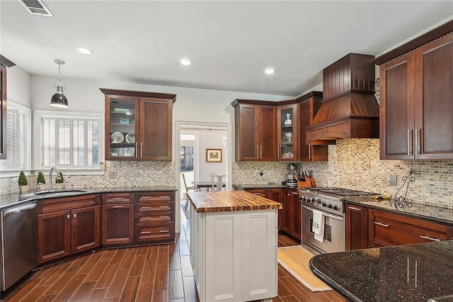 kitchen with decorative backsplash, sink, wood counters, stainless steel appliances, and custom exhaust hood