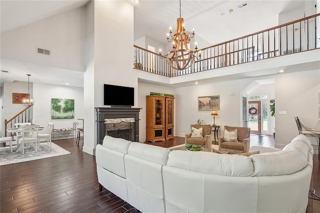living room with high vaulted ceiling, a fireplace, dark wood finished floors, a notable chandelier, and visible vents