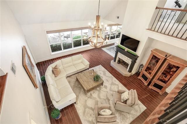 living room with wood-type flooring, high vaulted ceiling, and an inviting chandelier