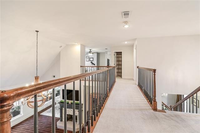 hall featuring an upstairs landing, carpet, lofted ceiling, visible vents, and recessed lighting