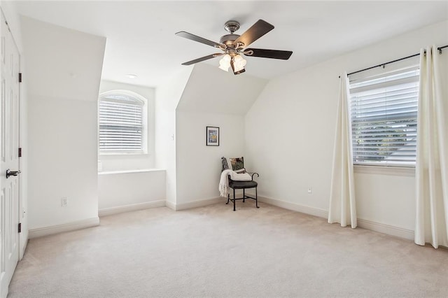 additional living space featuring light carpet, vaulted ceiling, and a healthy amount of sunlight