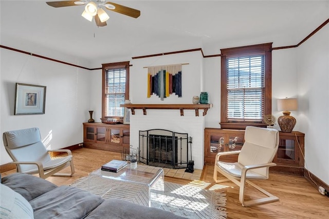 living room featuring crown molding, light wood-type flooring, a wealth of natural light, and ceiling fan