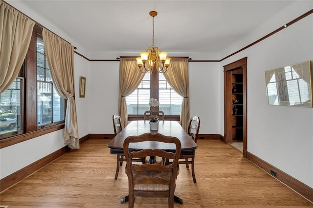 dining area featuring light hardwood / wood-style floors and an inviting chandelier