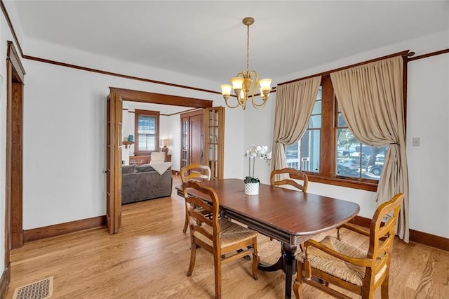 dining space featuring a notable chandelier and light hardwood / wood-style floors